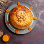 A golden-brown Passover potato pie served on a white plate, garnished with fresh herbs for added flavor