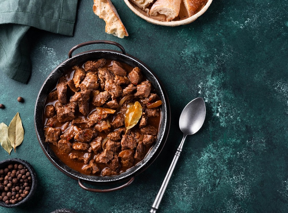 A beautifully cooked dish featuring tender and juicy beef cheek meat, garnished with fresh herbs and served with a side of vegetables.