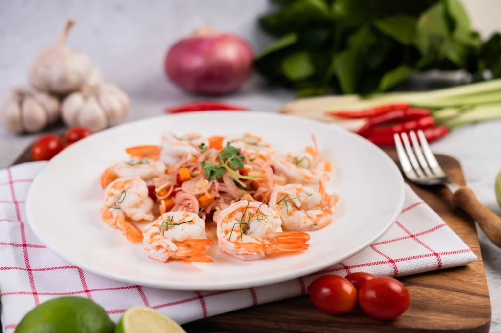 A close-up photo of a delicious shrimp garlic dish, with succulent shrimp sautéed in a fragrant garlic butter sauce, garnished with fresh parsley, and served on a white plate.