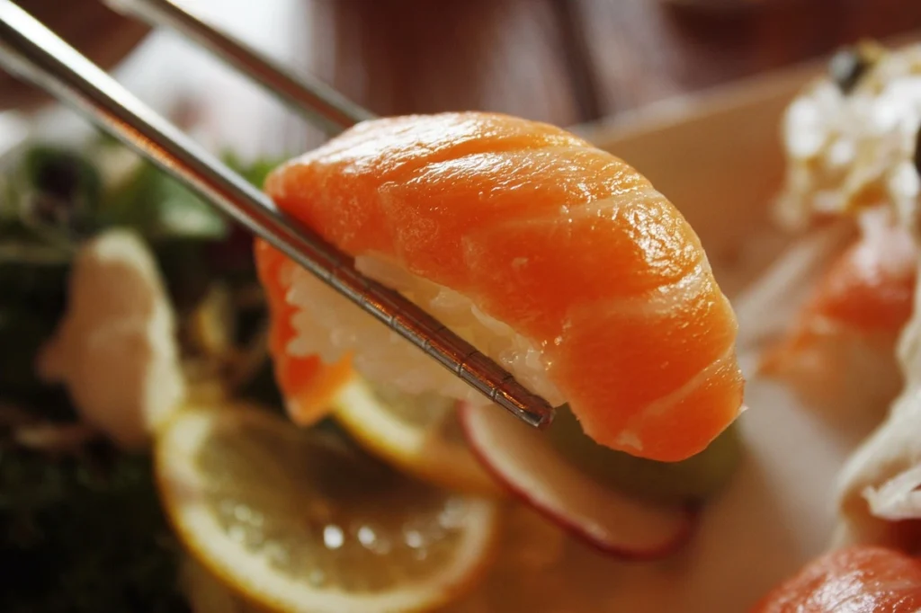 A stunning assortment of sushi orders with salmon, including fresh nigiri, sashimi, and vibrant sushi rolls, showcasing the rich orange tones of the fish.