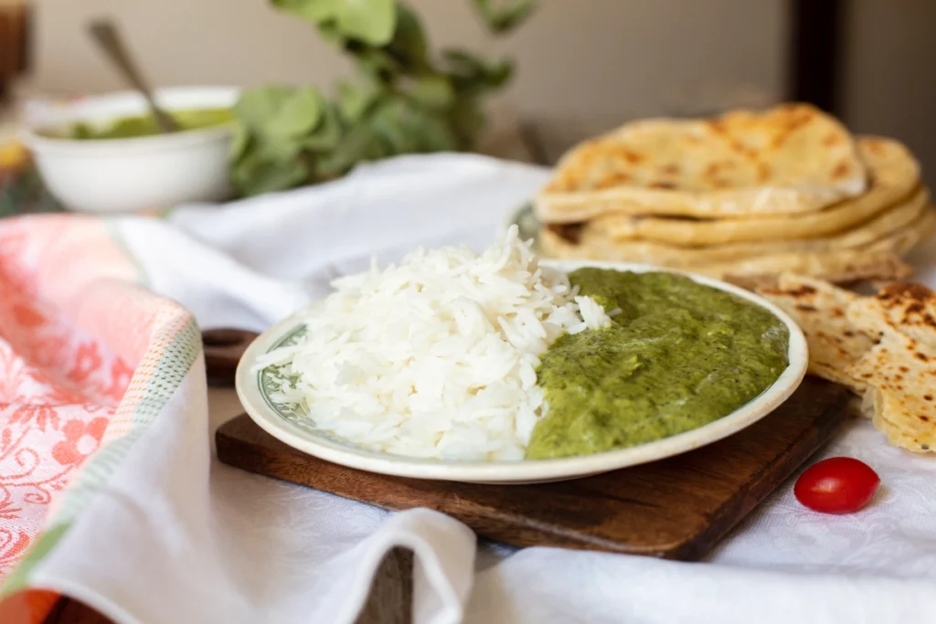 A close-up of Arroz Verde with cilantro and lime garnishing the dish.