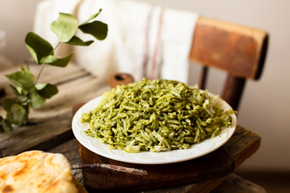 A plate of vibrant Arroz Verde with grilled chicken and vegetables.