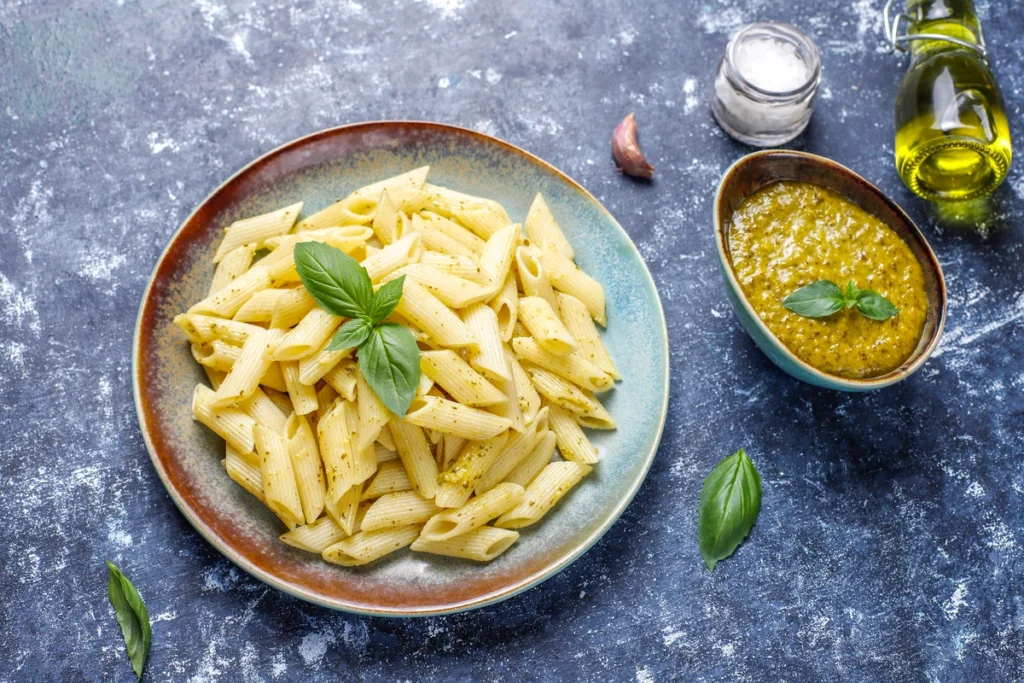 A bowl of Barilla Protein Pasta with grilled chicken, spinach, and a light pesto sauce