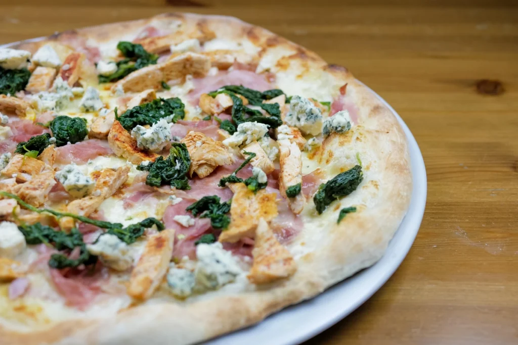 A homemade canned chicken pizza crust fresh out of the oven on a parchment-lined baking sheet.