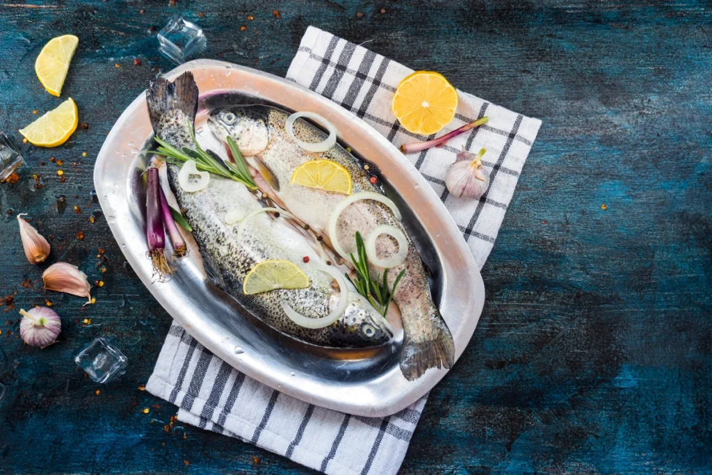 Grilled Loup de Mer served with lemon and herbs on a rustic plate.