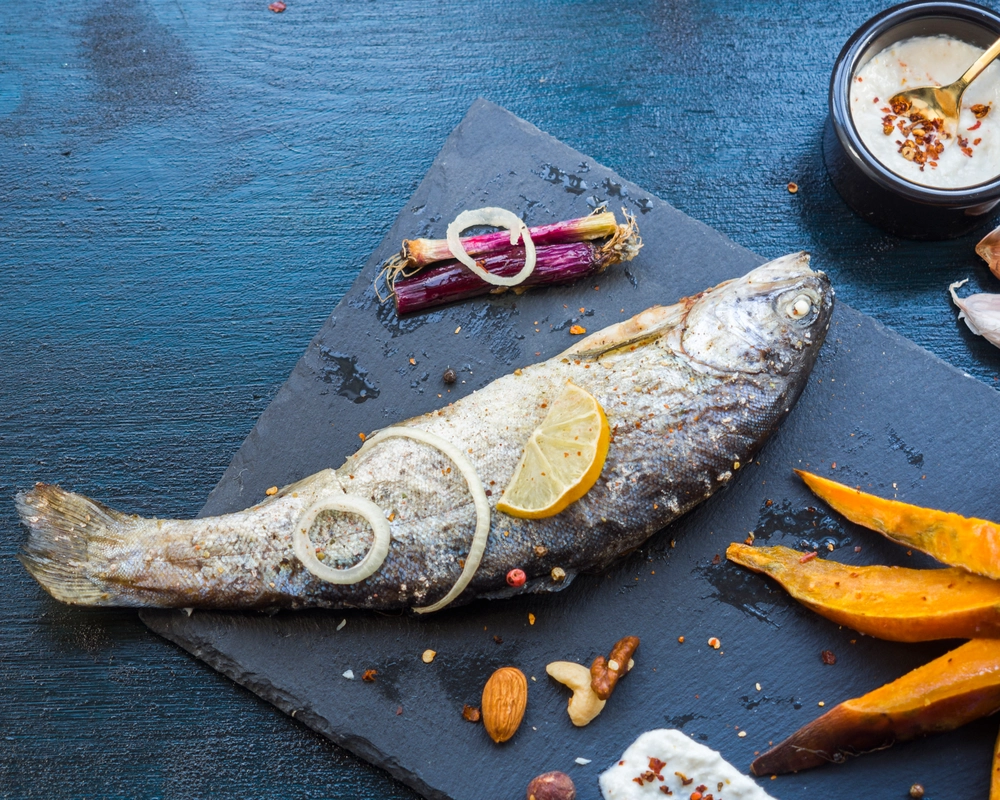 Fresh Loup de Mer fillets ready for cooking on a cutting board.