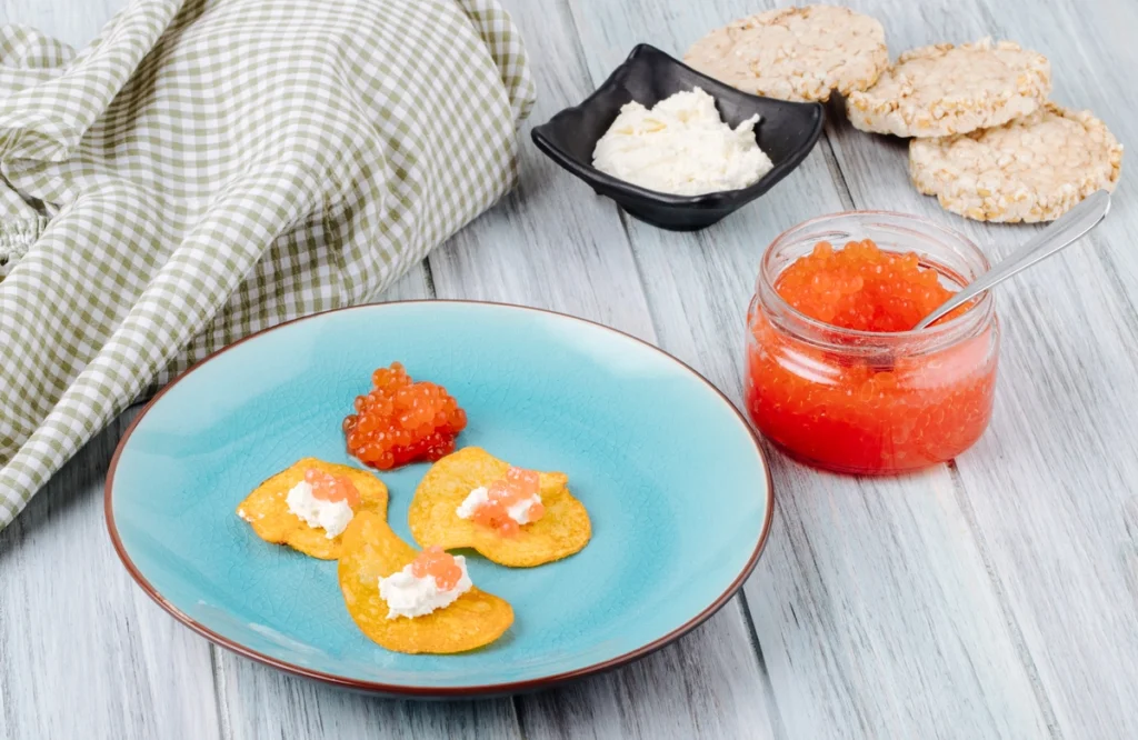 A spoonful of salmon roe placed on top of a fresh salad.