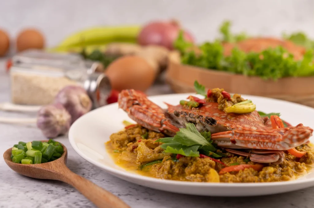 Stuffed crab served with roasted vegetables, a green salad, and garlic bread.