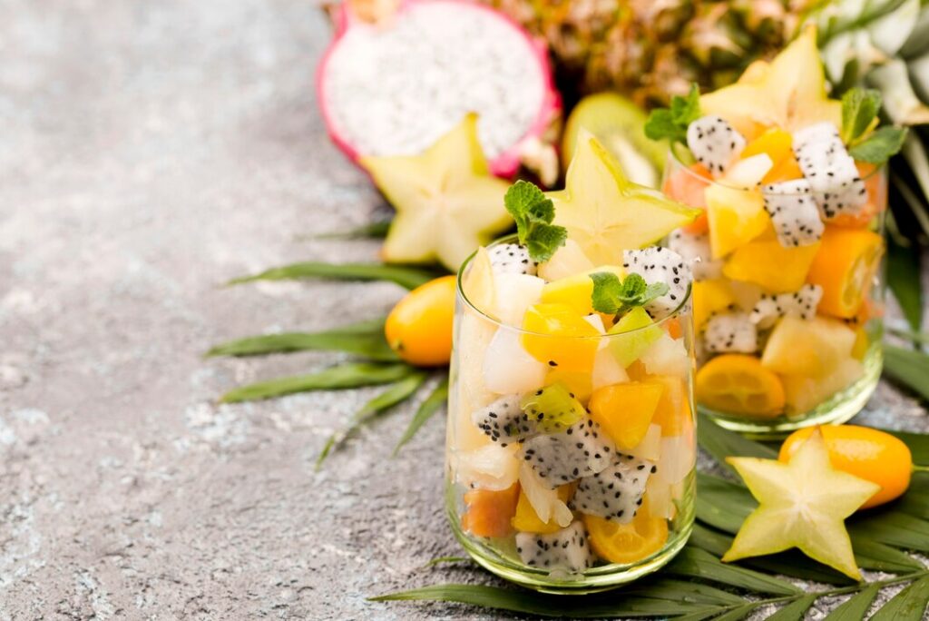 A sliced yellow dragon fruit showcasing its white, speckled flesh and black seeds, with the outer skin still attached.