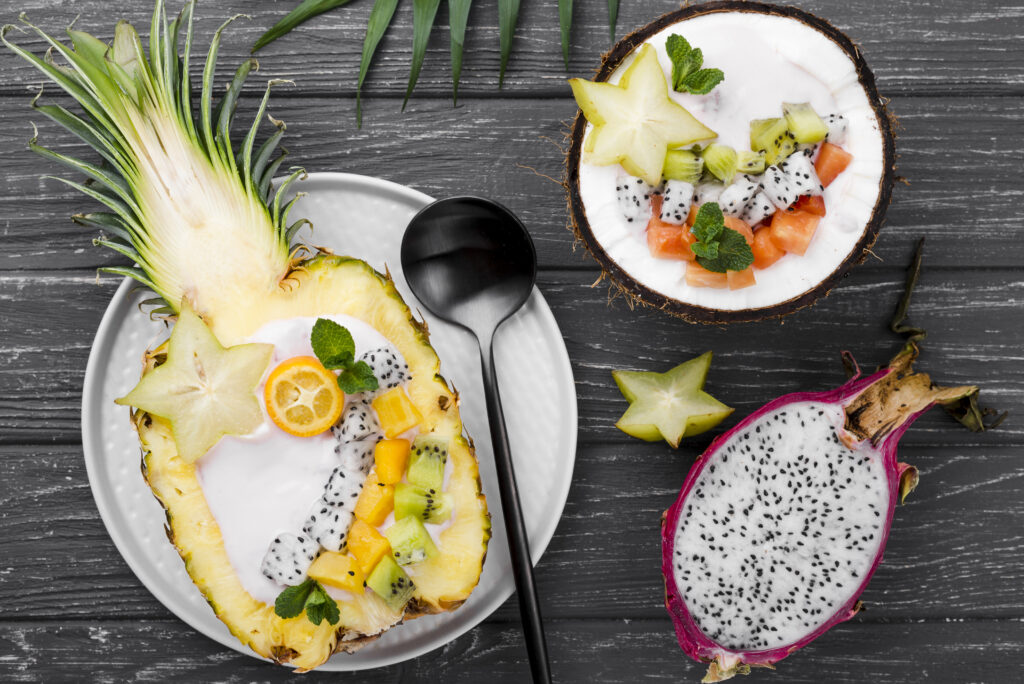 A hand holding a yellow dragon fruit with the vibrant yellow skin and spiky edges, ready to be sliced open.